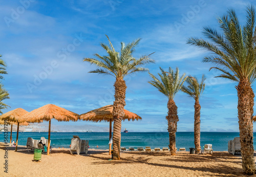 Morning on sandy with palm trees and resting facilities, Eilat, Israel