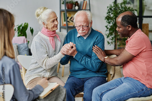 People talking and supporting senior man during psychotherapy with therapist