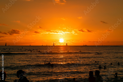 ハワイのワイキキビーチで見た、水平線に沈む太陽と夕焼け空 © 和紀 神谷