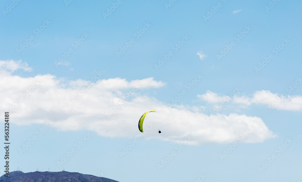 Flight to paraplene on the background of mountains and blue sky with clouds