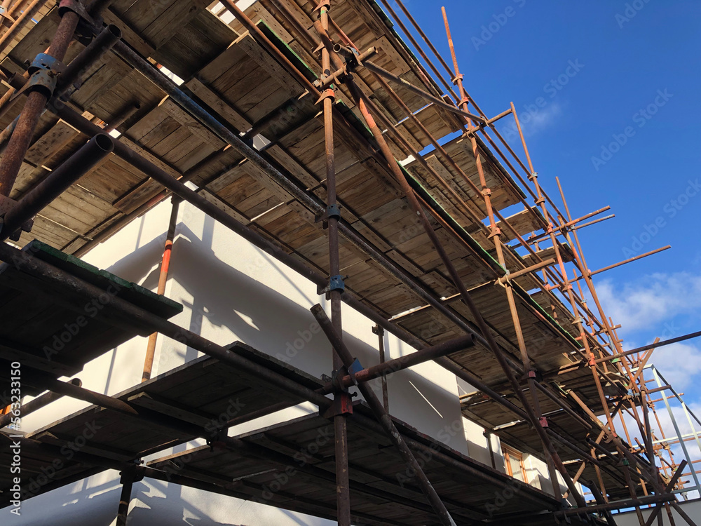 Scaffolding on the side of a house being renovated.