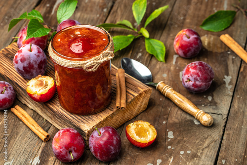 Jar with homemade plum jam on a wooden background. banner, menu, recipe place for text