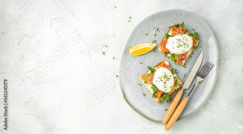 healthy breakfast with poached eggs, salmon and guacamole on toast. Long banner format. top view