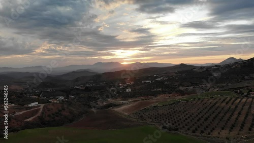4K sunset drone footage over beautiful houses, fields and mountains at Abdalajis valley, Antequera, Malaga, Spain.
Mid angle, traveling movement.