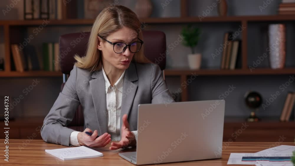 Confident female office worker conference video calling looking at laptop computer. Young businesswoman customer service manager speaking to webcam communicating in distance remote chat and making som