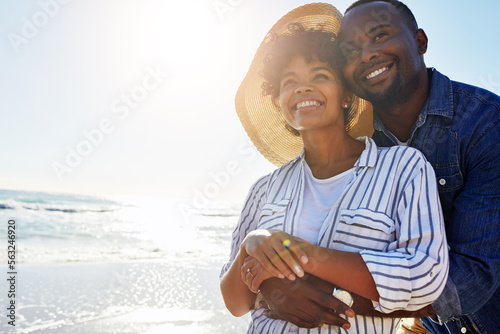 Beach hug, smile and black couple relax, travel and enjoy outdoor quality time together on Jamaica holiday mockup. Ocean sea water, blue sky flare and freedom peace mock up for happy bonding people #563246920