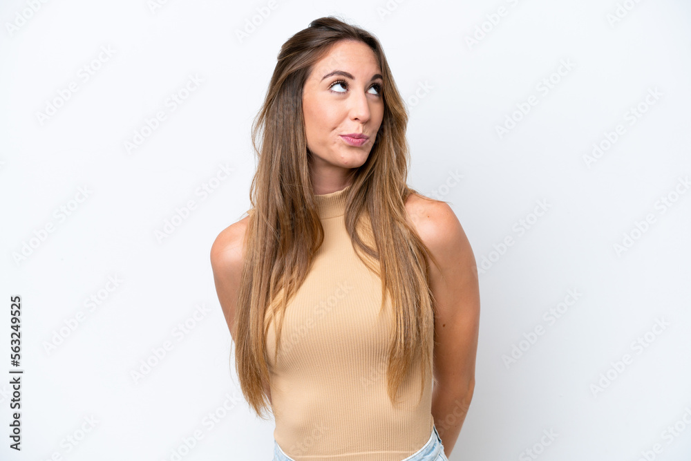 Obraz premium Young caucasian woman isolated on white background and looking up