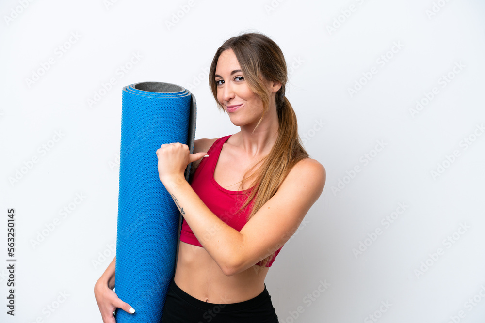Young sport woman going to yoga classes while holding a mat isolated on white background proud and self-satisfied Young sport woman going to yoga classes while holding a mat isolated on white background proud and self-satisfied