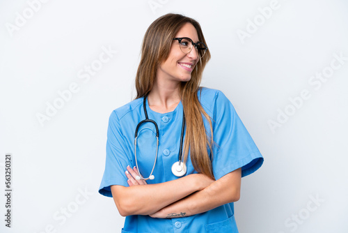 Young surgeon doctor woman isolated on blue background looking side