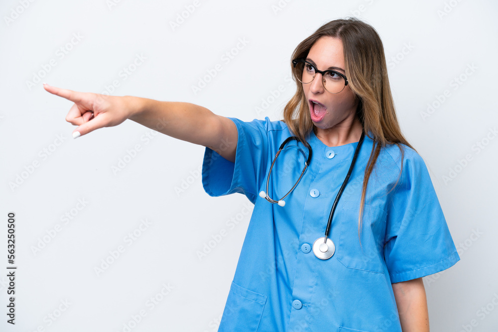 Young surgeon doctor woman isolated on blue background pointing away Young surgeon doctor woman isolated on blue background pointing away