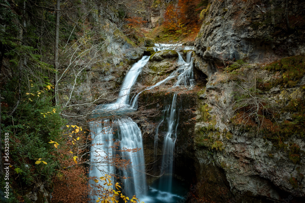 Autumn landscape with waterfall in Ordesa y Monte Perdido National Park in Pyrenees, Huesca, Spain - obrazy, fototapety, plakaty 