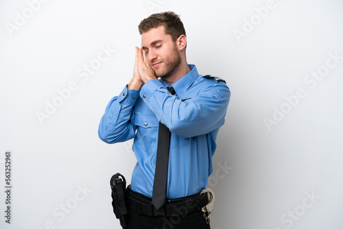 Young police caucasian man isolated on white background making sleep gesture in dorable expression photo