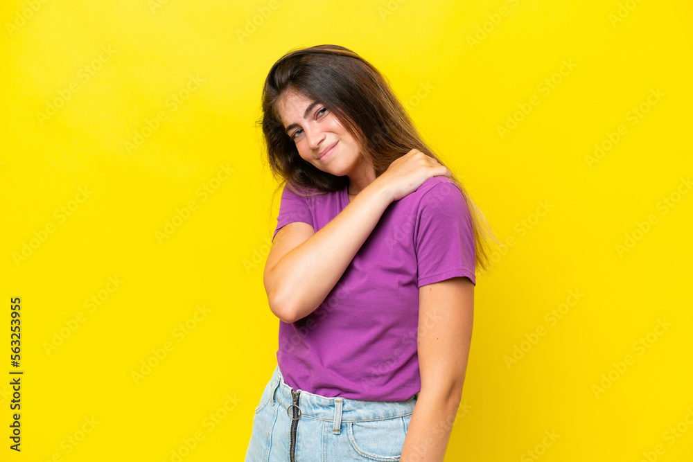Young caucasian woman isolated on yellow background suffering from pain in shoulder for having made an effort Young caucasian woman isolated on yellow background suffering from pain in shoulder for having made an effort