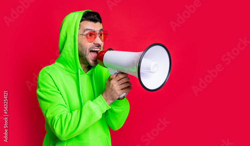 man announcer with loudspeaker isolated on red background, copy space. photo