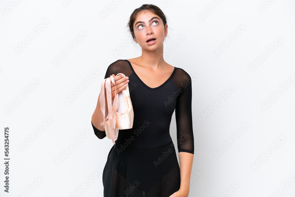 Young caucasian woman practicing ballet isolated on white background looking up and with surprised expression Young caucasian woman practicing ballet isolated on white background looking up and with surprised expression