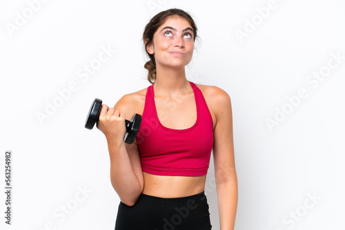 Young sport caucasian woman making weightlifting isolated on white background and looking up