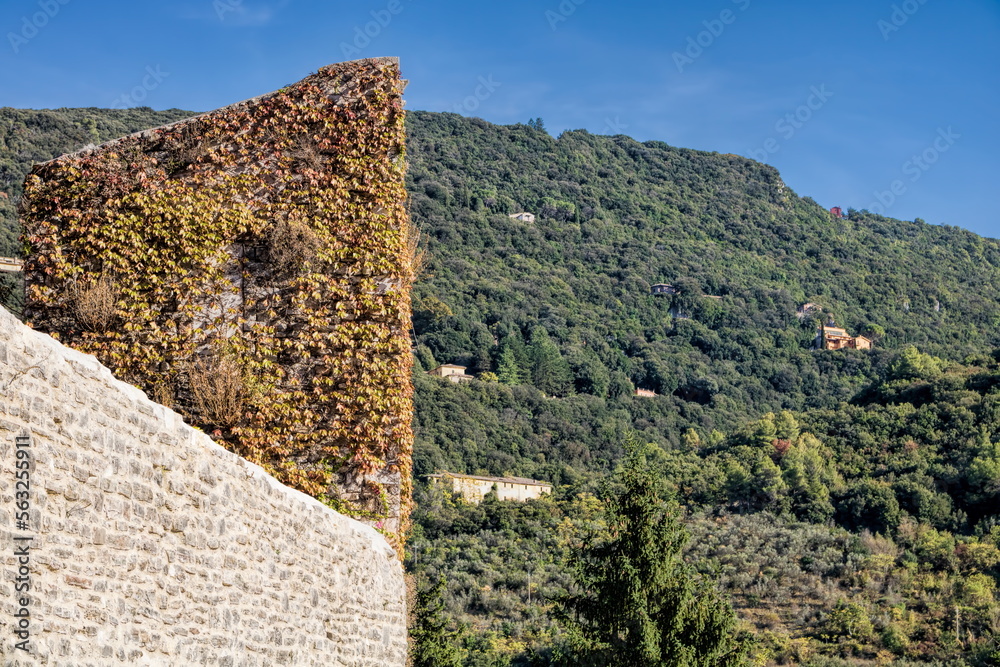 spoleto, italien - stadtmauer mit efeu bewachsen und grüne berge