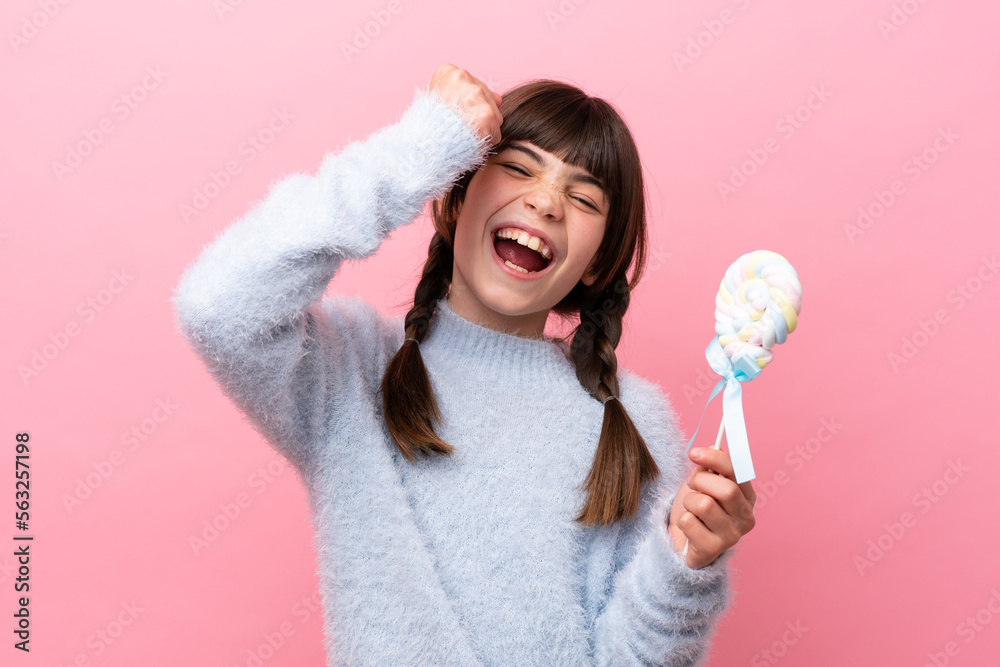 Little caucasian girl holding a lollipop celebrating a victory Little caucasian girl holding a lollipop celebrating a victory