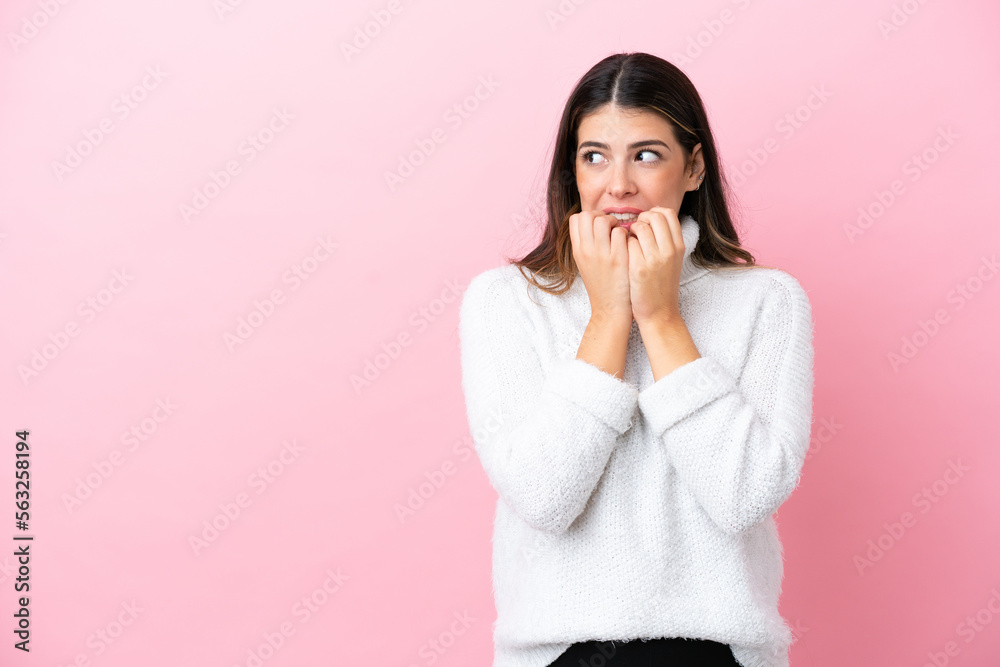 Young Italian woman isolated on pink background nervous and scared putting hands to mouth Young Italian woman isolated on pink background nervous and scared putting hands to mouth