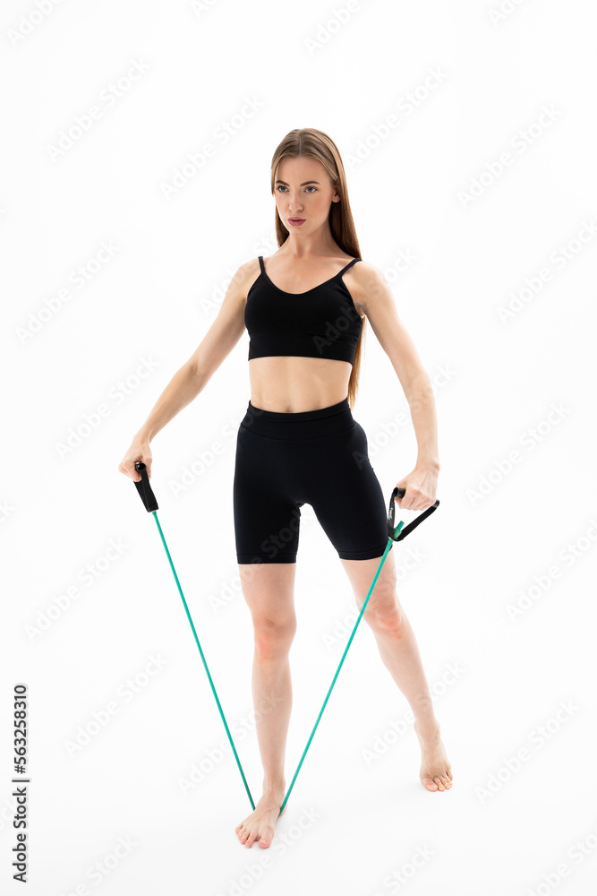 Beautiful girl in sportswear is training with an expander on a white background Beautiful girl in sportswear is training with an expander on a white background