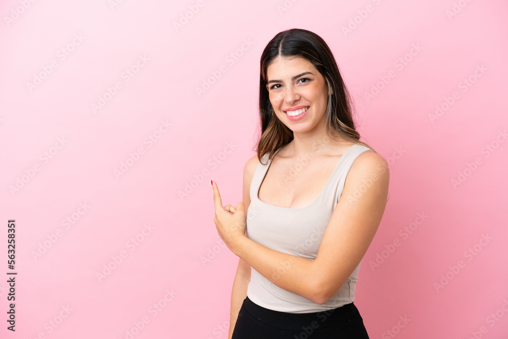 Young Italian woman isolated on pink background pointing back Young Italian woman isolated on pink background pointing back