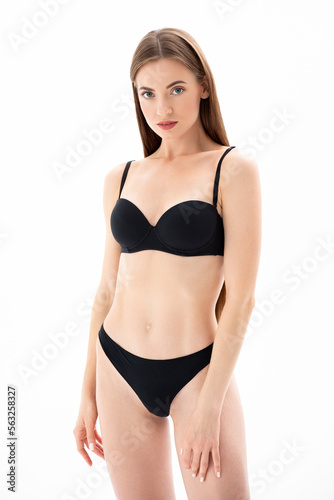 Young charming woman in black lingerie posing on a white Isolated background