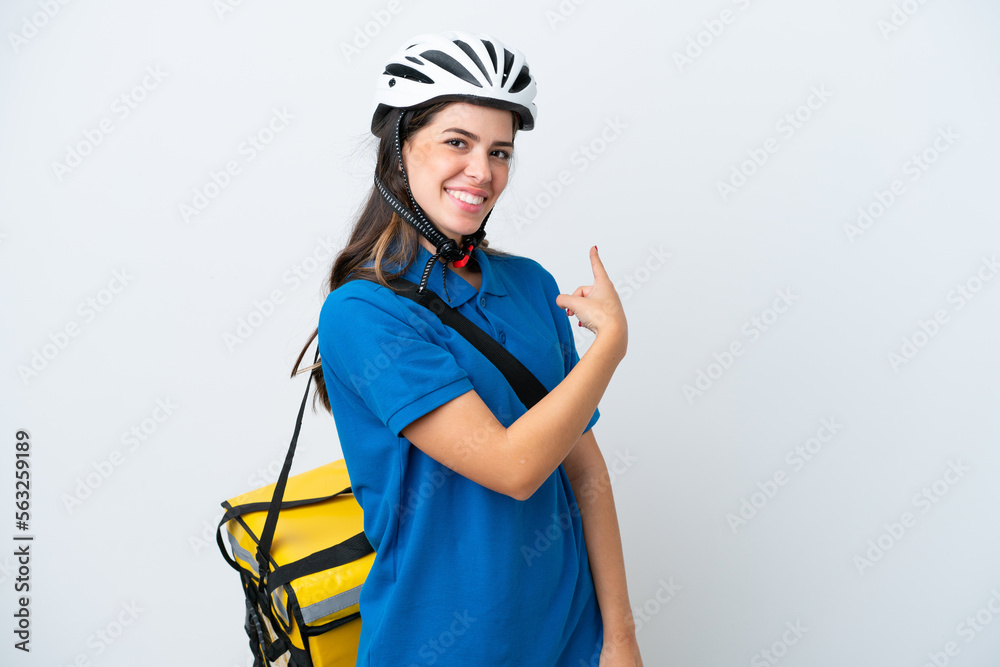 Young delivery woman with thermal backpack isolated on white background pointing back Young delivery woman with thermal backpack isolated on white background pointing back