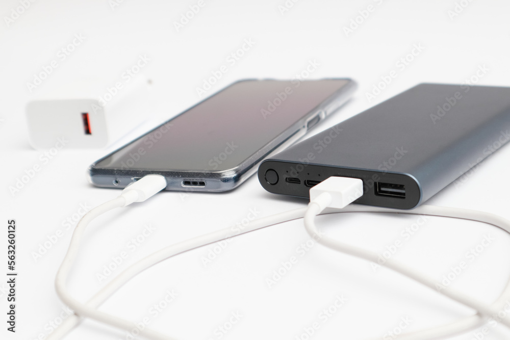 Power bank and smartphone on white background. Modern technology concept. Power bank and smartphone on white background. Modern technology concept.