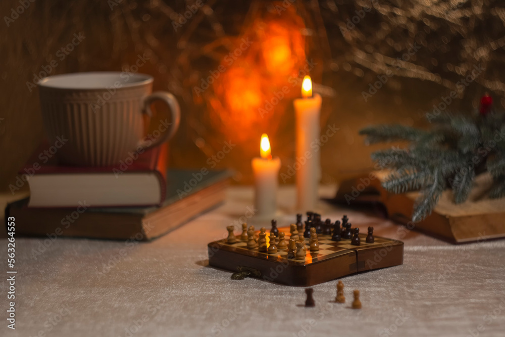 Cozy vintage composition, bringing a sense of warmth and festivity. Chessboard on the table among the books
