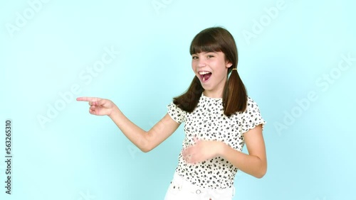 Little girl  pointing to the side and presenting a product while smiling over isolated background