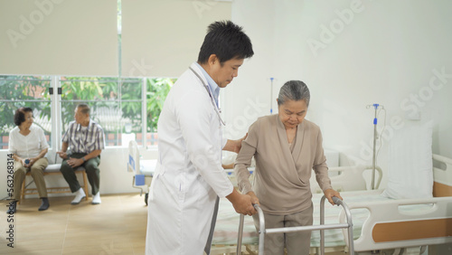 An Asian doctor with a group of old elderly patient or pensioner in nursing home in hospital. Senior people lifestyle activity recreation. Health care physical therapy.
