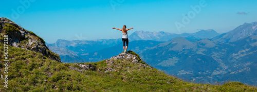 Happy woman on peak enjoying panoramic alps mountain view
