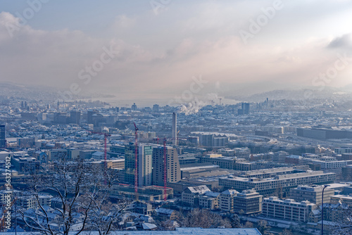 Aerial view over snow covered City of Zürich with Lake Zürich in the background on a blue cloudy late autumn day. Photo taken December 11th, 2022, Zurich, Switzerland.