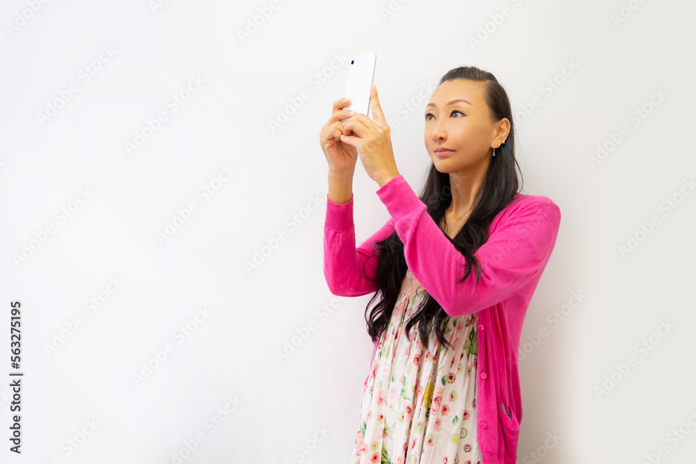 スマホで写真を撮る女性