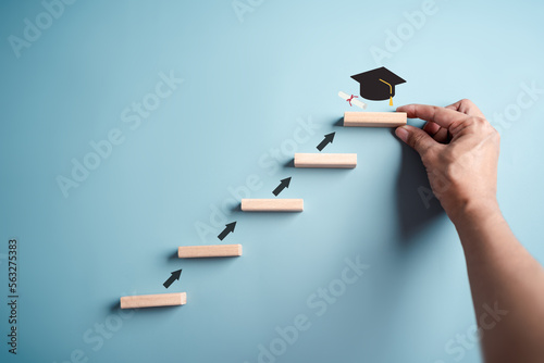 Steps of education leading to success goal. Taking strategic steps towards graduation. Career path and first for business, Graduation achievement goals concept. Graduation cap on wooden block. photo