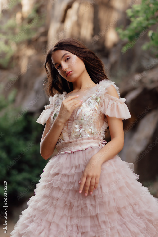 Fashionable young model in boho style dress on a background of rocks. Female beauty and style concept. Fashionable young model in boho style dress on a background of rocks. Female beauty and style concept.
