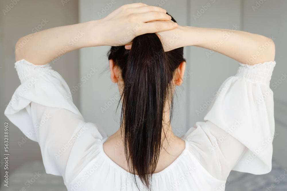 Healthy Shiny Long Hair in Tale. Beautiful Girl holding her Hair in hand. Back view on white. Smooth Hairstyle with strong Hair Healthy Shiny Long Hair in Tale. Beautiful Girl holding her Hair in hand. Back view on white. Smooth Hairstyle with strong Hair