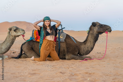 A Lovely Model Rides A Dromedary Camel Through The Saharan Desert On Their Camels In Morocco photo