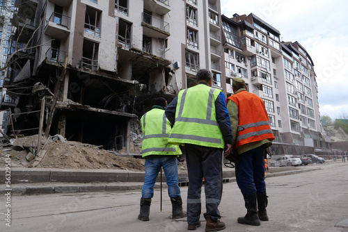 Workers clear rubble after bombing. Dwelling house damaged by russian missile