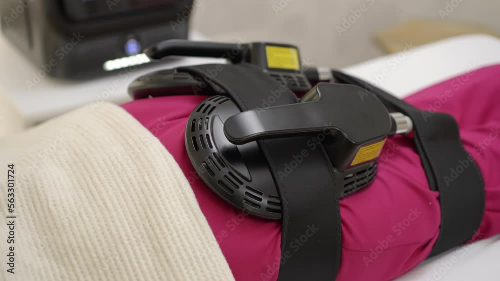 Close-up view of a young woman getting ems treatment on her buttocks to burn fat and build muscles and remove cellulite Close-up view of a young woman getting ems treatment on her buttocks to burn fat and build muscles and remove cellulite