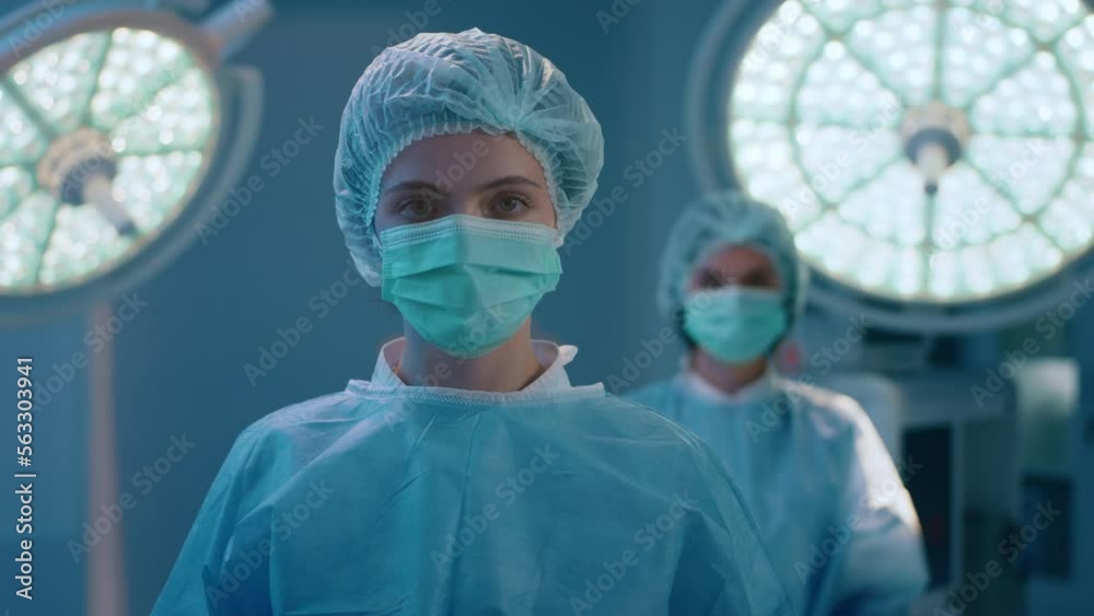 Two beautiful surgical nurses are dressed full ready for a surgery in a medical room with very bright lighting Two beautiful surgical nurses are dressed full ready for a surgery in a medical room with very bright lighting