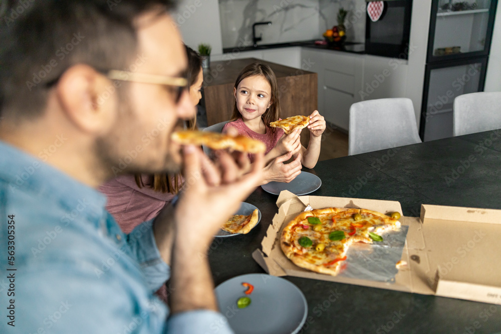 Happy family eating pizza at home Happy family eating pizza at home