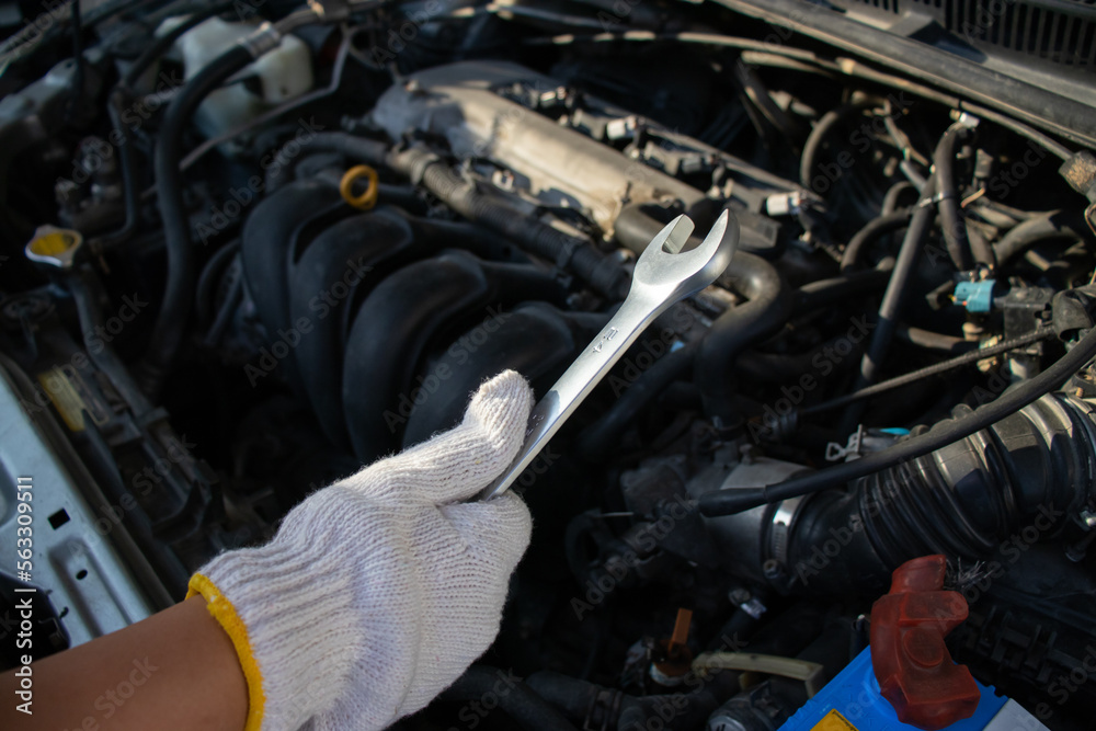 Mechanic checking vehicle repairs Mechanic using wrench to check engine Adjust checks according to industry standards to prevent problems with technology equipment part of the engine. check engine oil Mechanic checking vehicle repairs Mechanic using wrench to check engine Adjust checks according to industry standards to prevent problems with technology equipment part of the engine. check engine oil