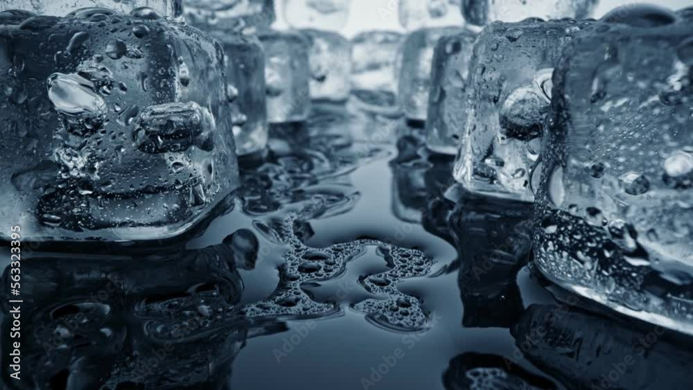 Melted ice cubes close up. Camera moves through ice cubes with water drops over dark background. Wet melted ice cubes with waterdrops. Ice super macro. Slider shot, 4K UHD