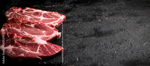 Fresh uncooked pork steak on a stone board. 