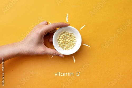 Tablets on a plate inside a picture of the sun and the inscription: vitamin D