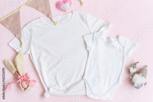 Easter mom and kids mockup white t-shirt and baby bodysuit onesie with bunny and easter eggs on pink cover background. Flatlay, top view, copyspace.