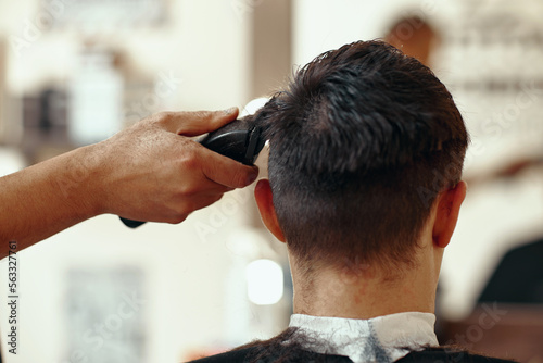 Barber shaving caucasian man in barber shop