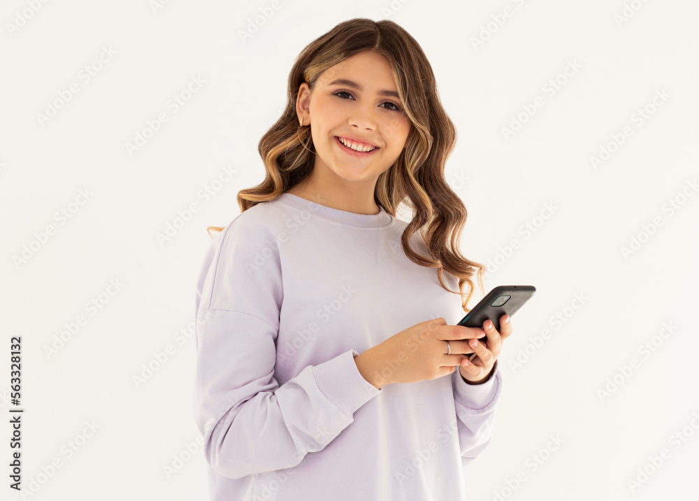Smiling wavy woman with smartphone in hands looking at the camera over white background Smiling wavy woman with smartphone in hands looking at the camera over white background
