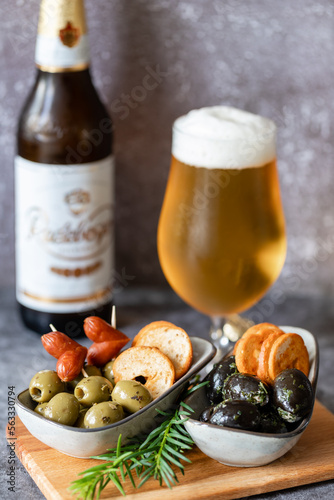 Delicious Italian appetizer for a glass of beer, green and black olives with herbs in olive oil